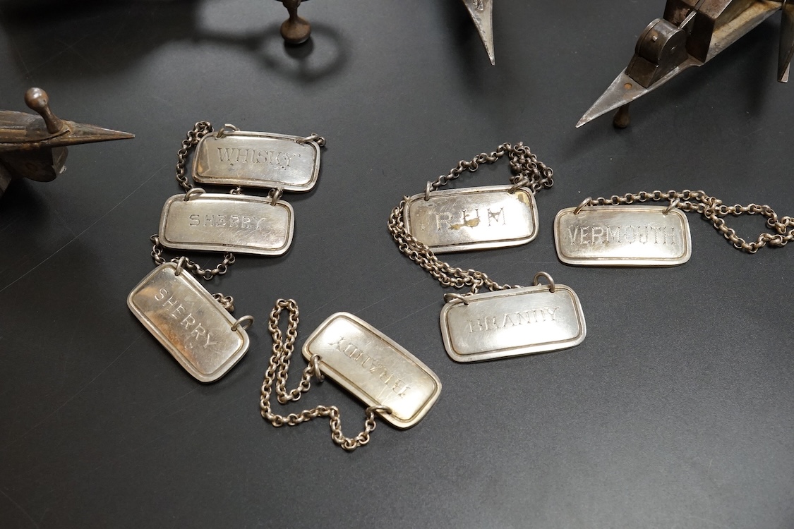 Four assorted pairs of 19th century plated candle snuffers, a large plated box, plated cream jug, ball and seven plated wine labels. Box 10cm high x 16.5cm wide.
